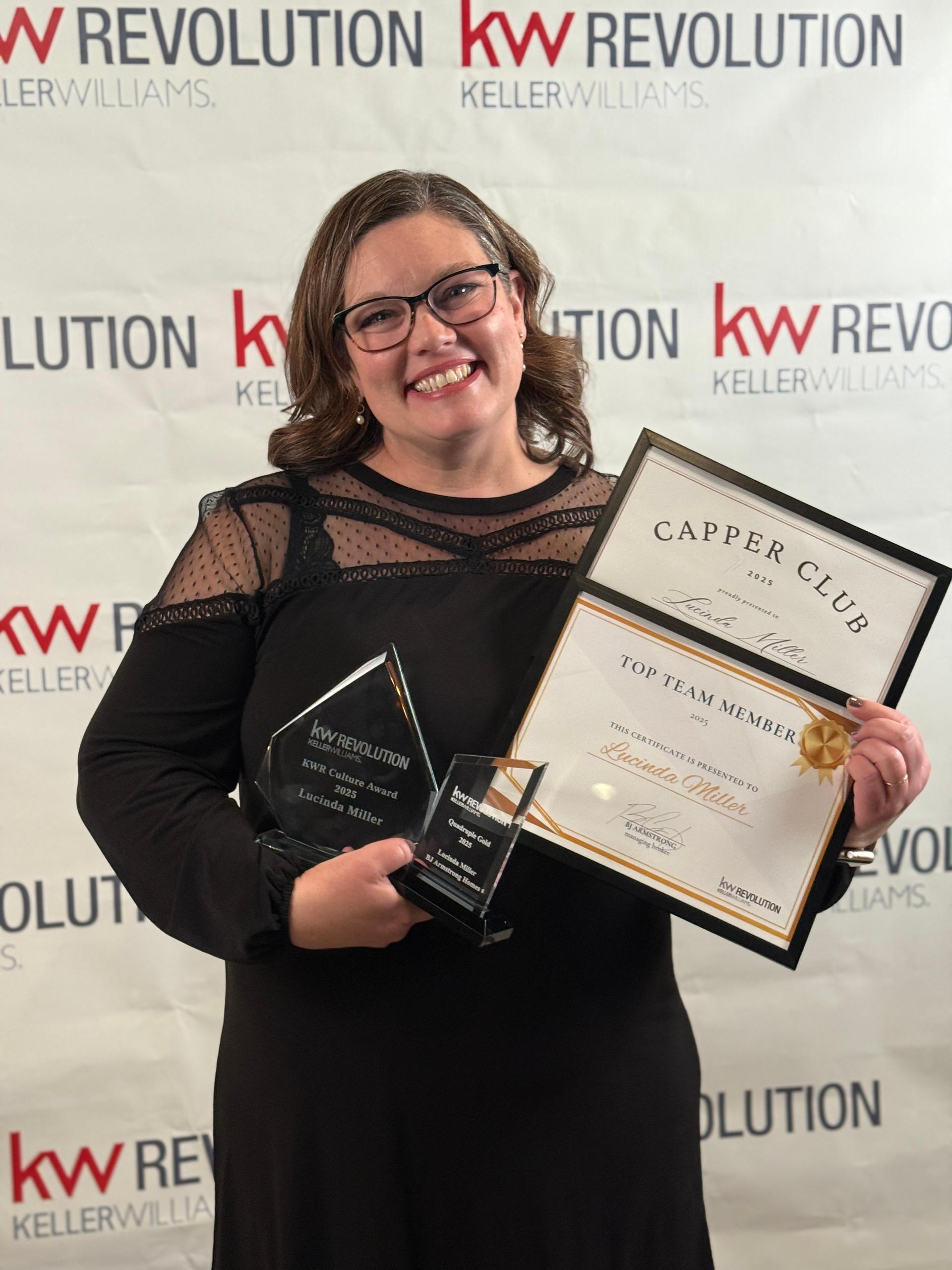 Lucinda Miller, award-winning Realtor®, holding her 2025 Keller Williams awards